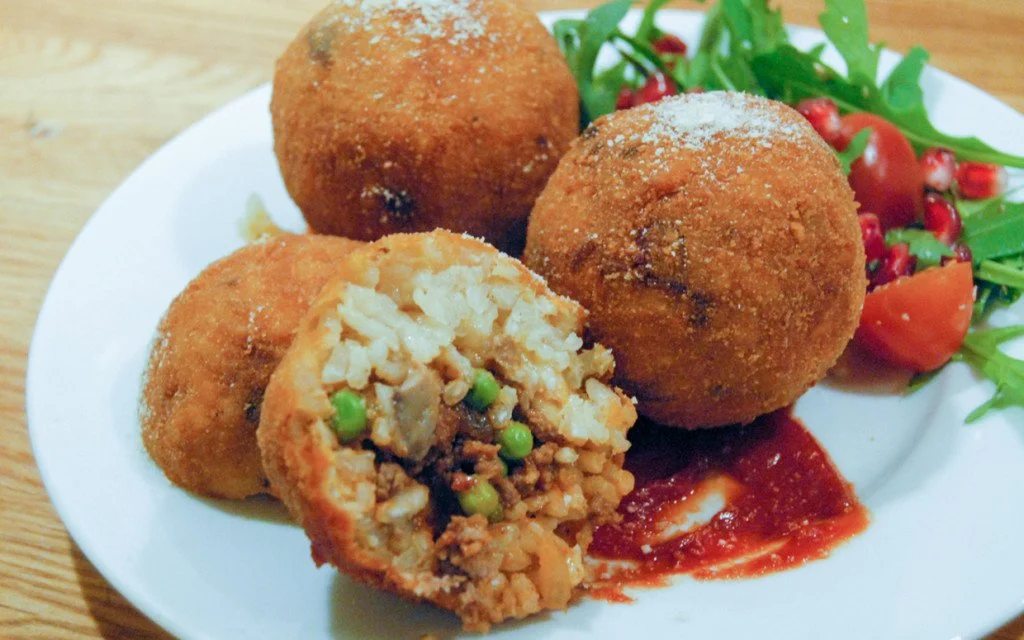 Arancini are crispy stuffed rice balls and are a must try when in Italy. ouritalianjourney.com