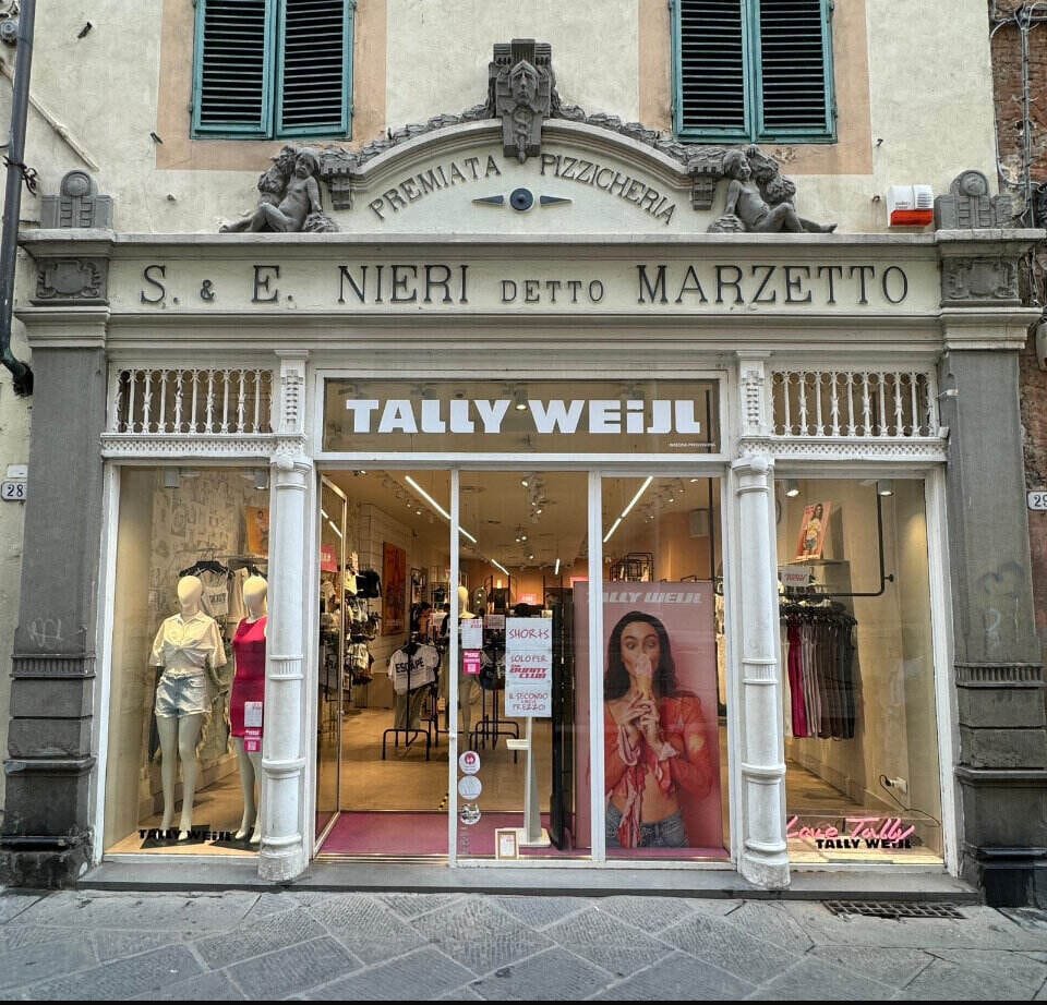 Clashing store signs in Lucca, Italy - ouritalianjourney.com